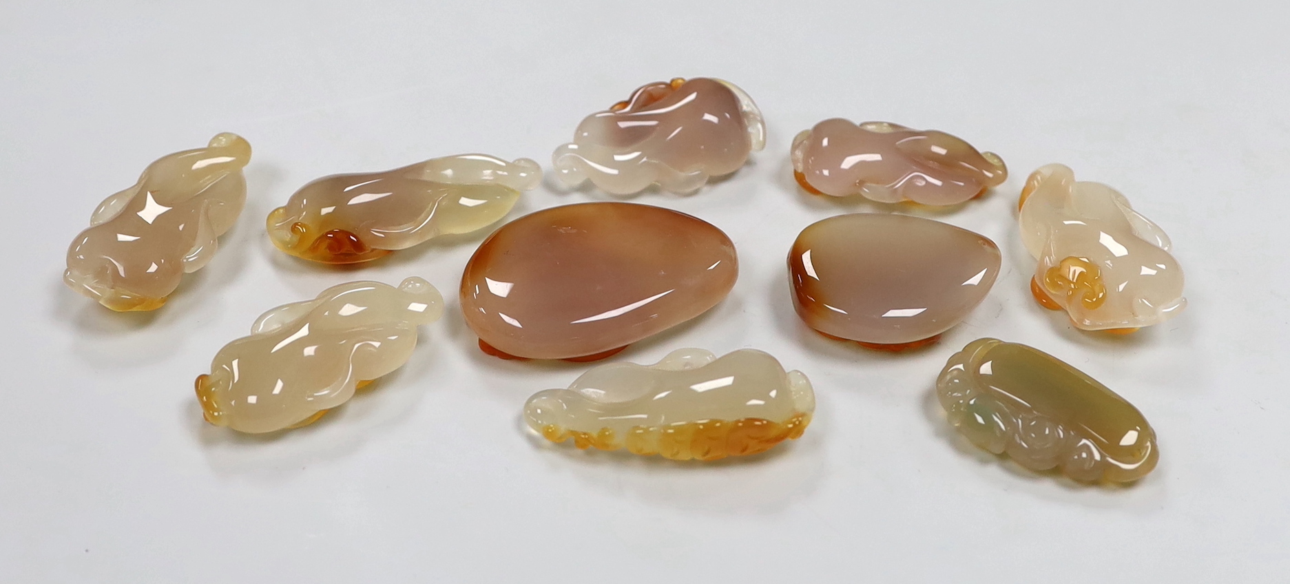 Ten Chinese agate carved pendants, the largest 6cm wide